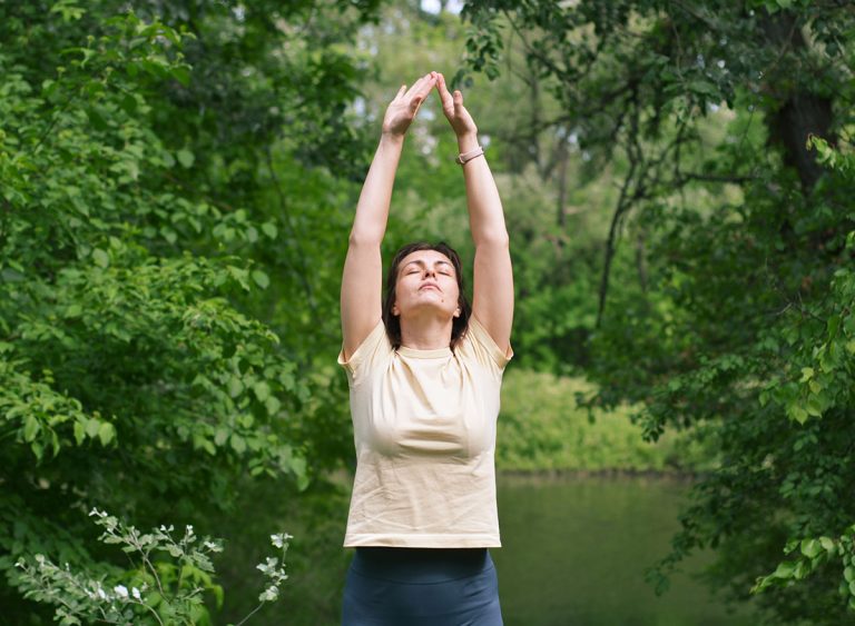 Calm,Woman,Practicing,Yoga,Outside,,Stretching,Arms,Overhead.,Serene,Nature