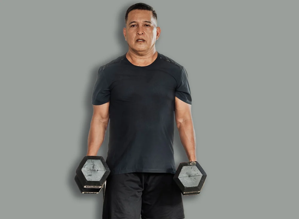 Middle-aged,Southeast,Asian,Man,Carries,Two,Dumbbells,In,A,Farmerís