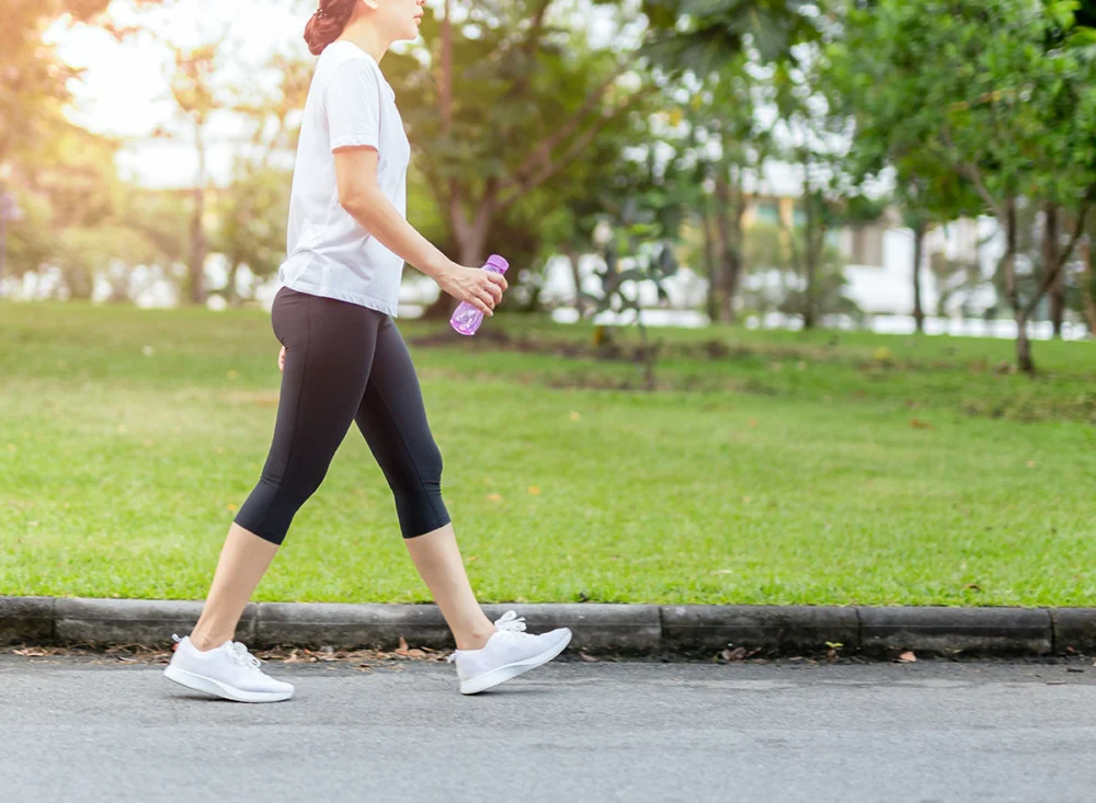 Woman,Walking,In,The,Park,With,Bottle,Water,In,Summer