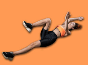 Young,Woman,Exercising,Dead,Bug,With,Personal,Trainer,In,Gym