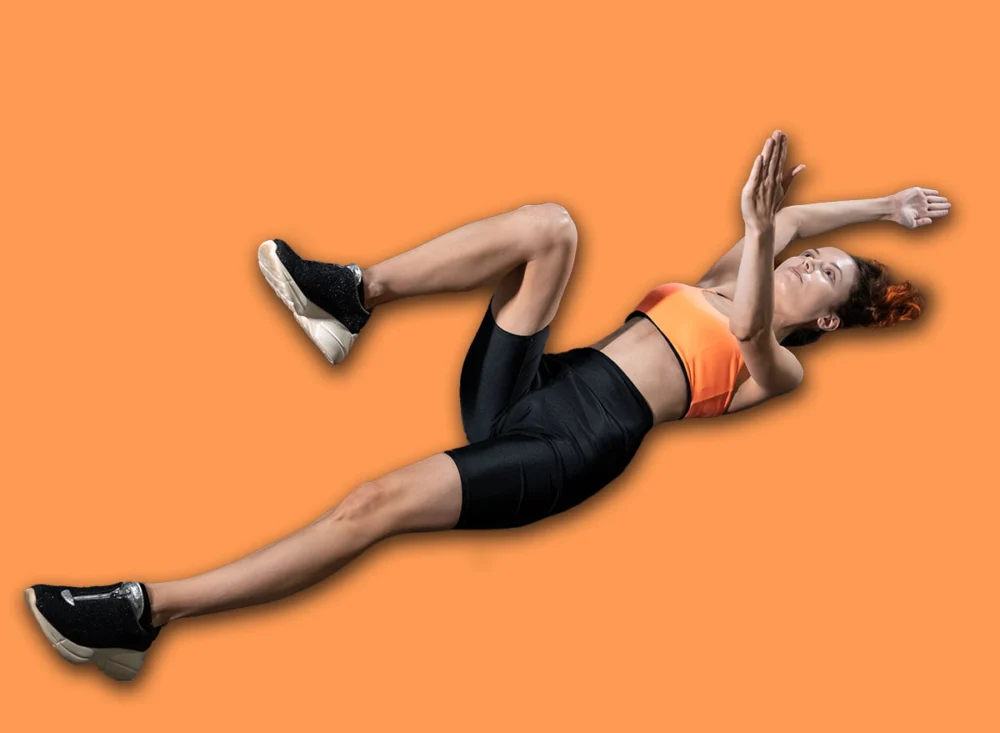 Young,Woman,Exercising,Dead,Bug,With,Personal,Trainer,In,Gym