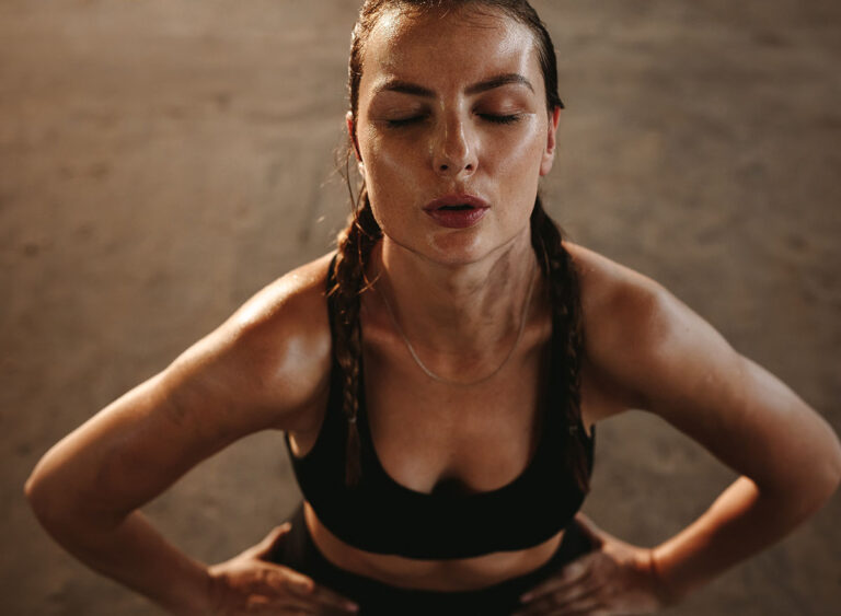 Fit,Woman,With,Her,Hands,On,Her,Hips,Taking,Deep