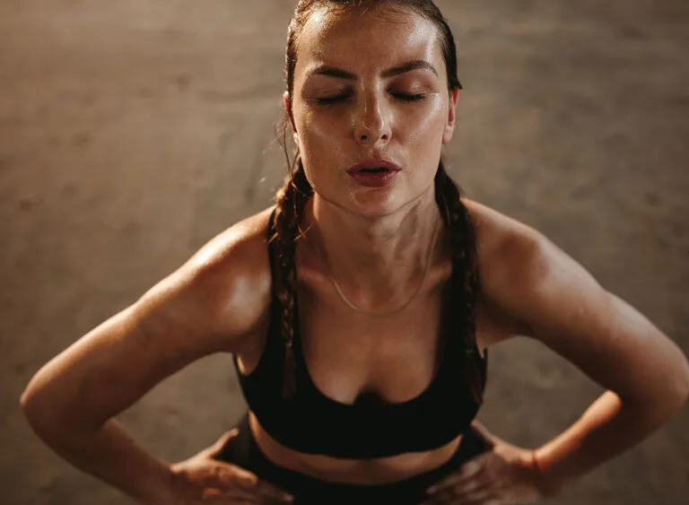 Fit,Woman,With,Her,Hands,On,Her,Hips,Taking,Deep