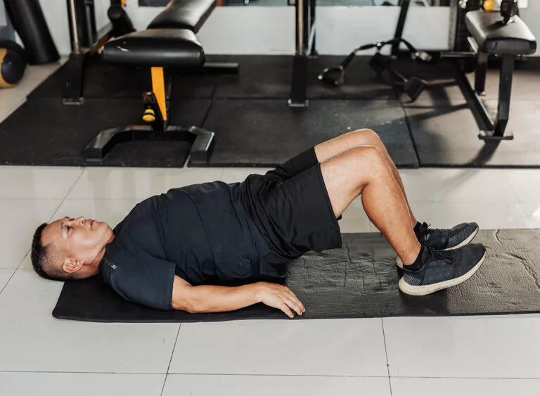 Southeast,Asian,Man,In,His,50s,Performs,Glute,Bridge,Exercise