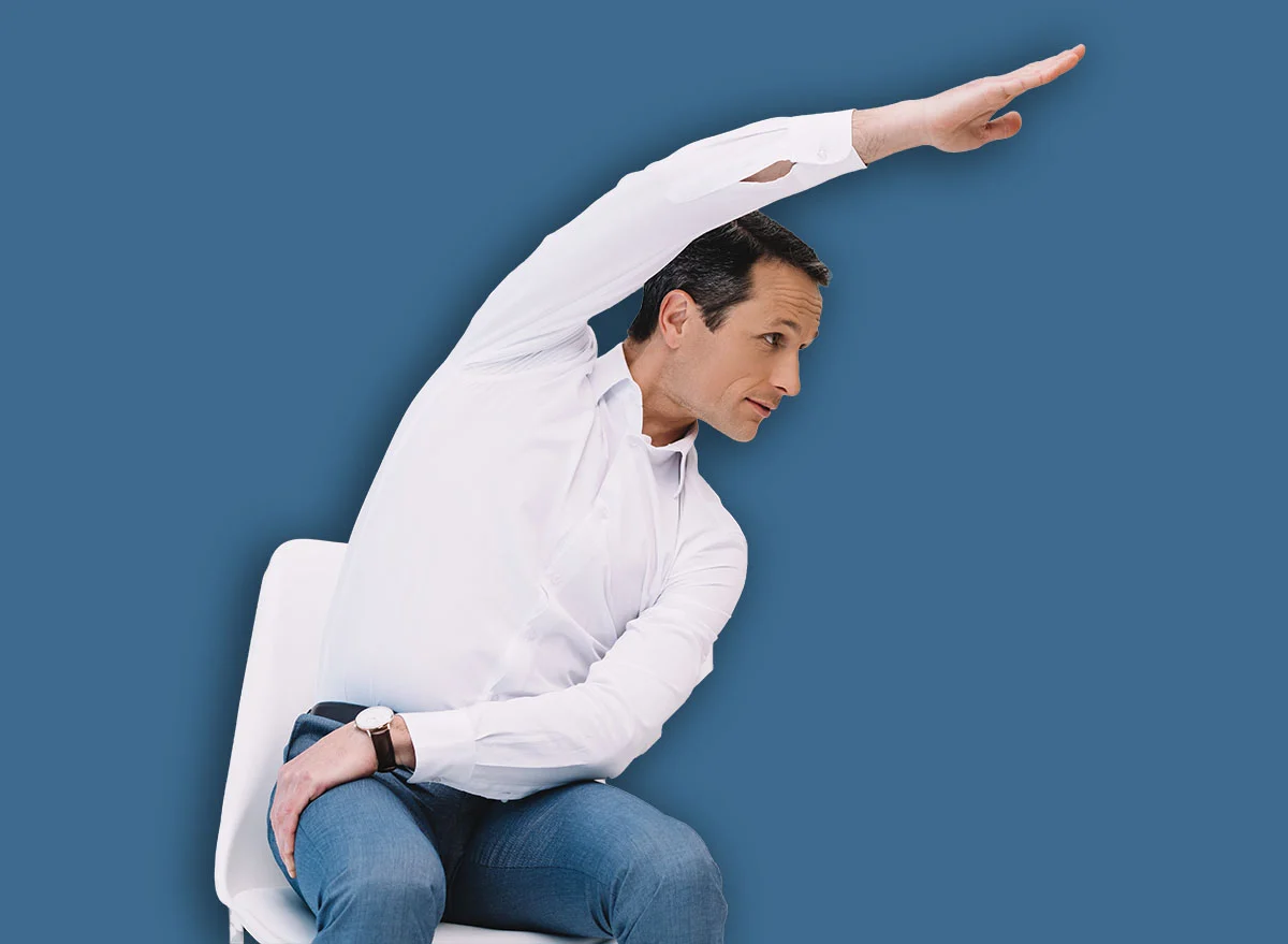 Middle,Aged,Businessman,Doing,Side,Bend,On,Chair,At,Office