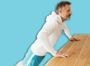 Side-view,Ofa,Determined,Middle-aged,Man,Exercising,Push-ups,On,A,Table