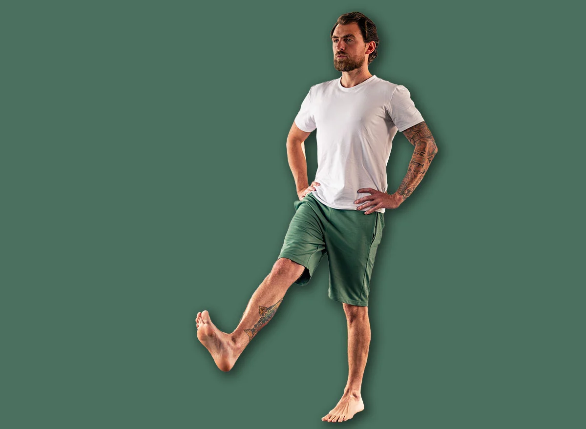 Man,Practicing,Yoga,In,Studio,,Standing,On,One,Leg,With