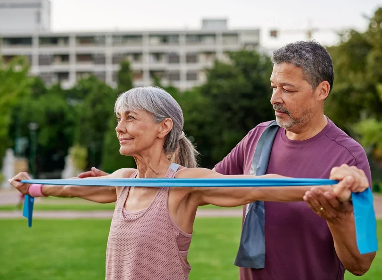 Senior,Multiethnic,Couple,Using,A,Resistance,Band,During,Outdoor,Exercise.