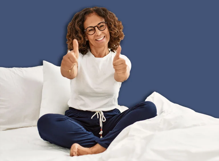 Middle,Age,Hispanic,Woman,Sitting,On,The,Bed,At,Home