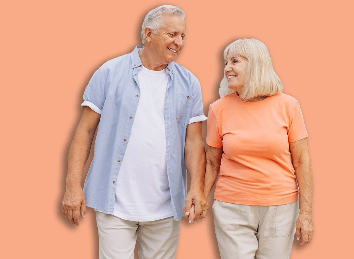 A,Joyful,Elderly,Couple,Holding,Hands,And,Walking,In,A